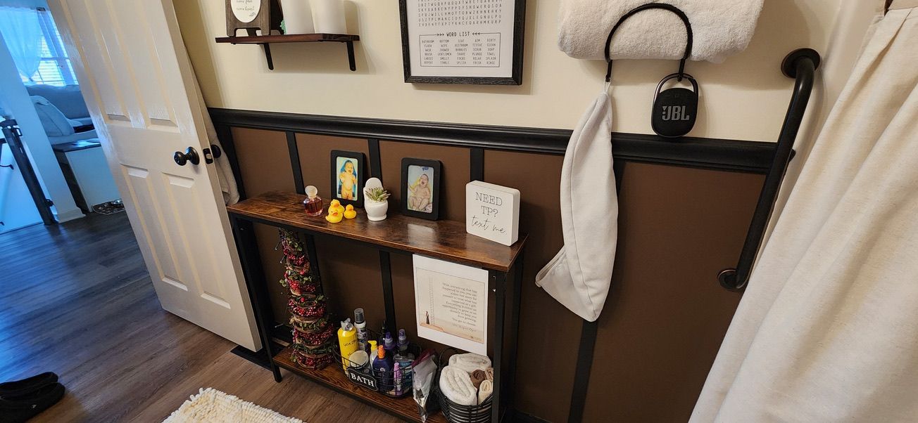 Bathroom wall with dark board-and-batten wainscoting and towel storage above